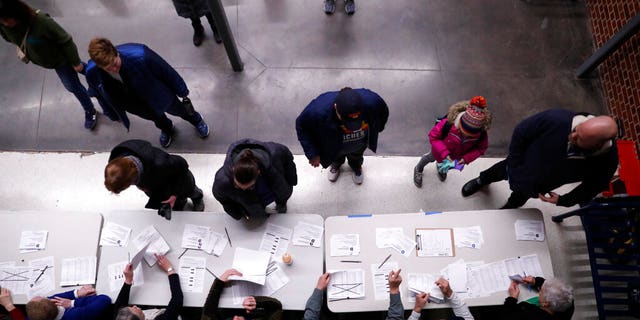 Caucus goers check in at a caucus at Roosevelt High School, Monday, Feb. 3, 2020, in Des Moines, Iowa. (AP Photo/Andrew Harnik)