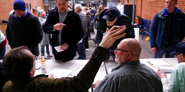 Caucus goers check in at a caucus at Roosevelt High School, Monday, Feb. 3, 2020, in Des Moines, Iowa. (AP Photo/Andrew Harnik)