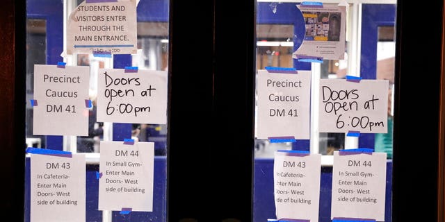 Directional signs are posted on doors at a caucus at Roosevelt Hight School, Monday, Feb. 3, 2020, in Des Moines, Iowa. (AP Photo/Andrew Harnik)