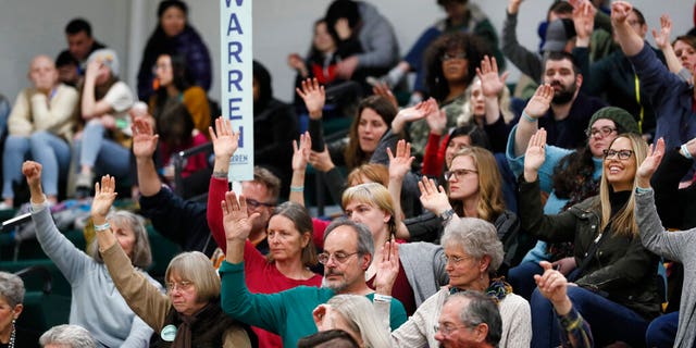 Supporters for Democratic presidential candidate Sen. Elizabeth Warren, D-Mass., raise their hands to be counted during a Democratic party caucus at Hoover High School, Monday, Feb. 3, 2020, in Des Moines, Iowa. (AP Photo/Charlie Neibergall)