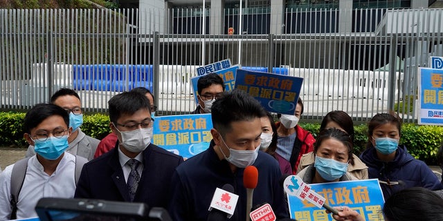 Pro-China supporters wearing masks urge government to deliver masks to local people during a protest in Hong Kong on Tuesday. Hong Kong reported its first death from a new virus, a man who had traveled from the mainland city of Wuhan that has been the epicenter of the outbreak. (AP Photo/Vincent Yu)