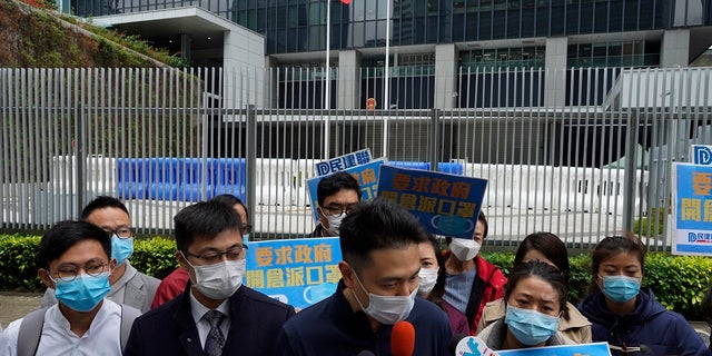 Pro-China supporters wearing masks urge government to deliver masks to local people during a protest in Hong Kong on Tuesday. Hong Kong reported its first death from a new virus, a man who had traveled from the mainland city of Wuhan that has been the epicenter of the outbreak. (AP Photo/Vincent Yu)
