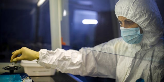 A medical staffer works with test systems for the diagnosis of coronavirus, at the Krasnodar Center for Hygiene and Epidemiology microbiology lab in Krasnodar. (AP Photo)