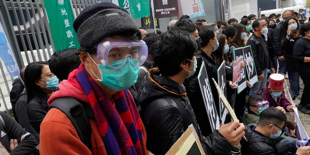 Medical staff strike over coronavirus concerns outside government headquarters in Hong Kong on Wednesday. In Hong Kong, hospitals workers are striking to demand the border with mainland China be shut completely to ward off the virus, but four new cases without known travel to the mainland indicate the illness is spreading locally in the territory.(AP Photo/Vincent Yu)