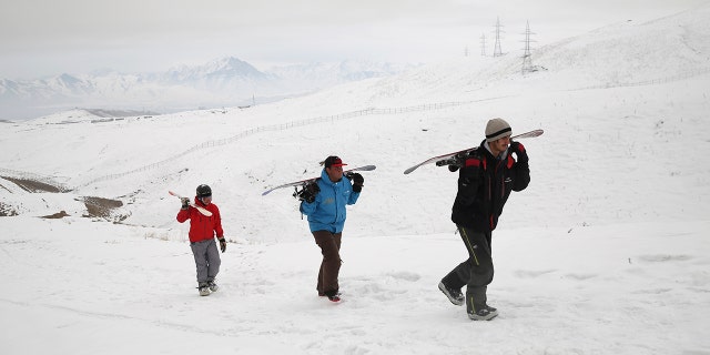 In this Friday, Jan. 24, 2020, photo, a group of snowboarders hike up the snow-covered hillside known as Kohe Koregh, on the outskirts of Kabul, Afghanistan. While Afghanistan’s capital may seem an unlikely destination for snowboarders, a group of young Afghans is looking to put the city on the winter sports map and change perceptions about their war-weary nation. (AP Photo/Rahmat Gul)