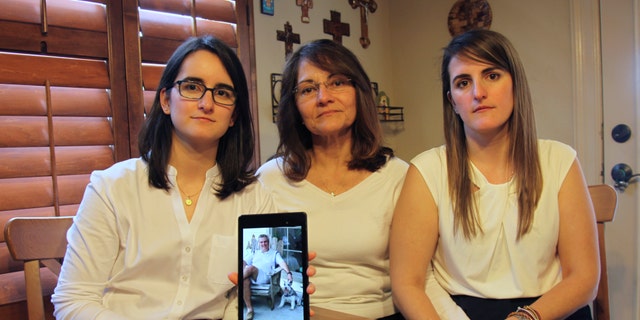 In this Feb. 15, 2019 file photo, Dennysse Vadell sits between her daughters Veronica, right, and Cristina holding a digital photograph of father and husband Tomeu who is currently jailed in Venezuela with five other executives from Houston-based Citgo, in Katy, Texas, Friday. (AP Photo/John L Mone, File, File)