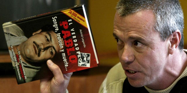 FILE: Jhon Jairo Velasquez, a former hitman for Pablo Escobar, known by his nickname "Popeye," gives his testimony while holding a book titled "The True Pablo, Blood, Treason, and Death," during the trial against Alberto Santofimio Botero in Bogota, Colombia.