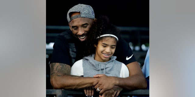Kobe Bryant and his daughter Gianna watch during the U.S. national championships swimming meet in Irvine, Calif. 