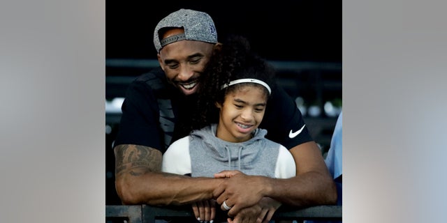 Kobe Bryant and his daughter Gianna watch during the U.S. national championships swimming meet in Irvine, Calif.