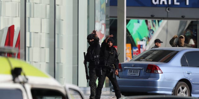 Armed commando soldiers shout for ambulance outside Terminal 21 Korat mall in Nakhon Ratchasima, Thailand, Sunday, Feb. 9, 2020. (Associated Press)