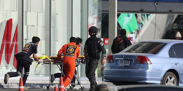 Medics carry a stretcher towards Terminal 21 Korat mall as commando soldiers work the scene of a shooting at the mall in Nakhon Ratchasima, Thailand, Sunday, Feb. 9, 2020. (Associated Press)