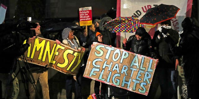Campaigners chant slogans outside Downing Street as they protest against government plans to deport 50 people to Jamaica, in London, Monday, Feb. 10, 2020. (Aaron Chown/PA via AP)
