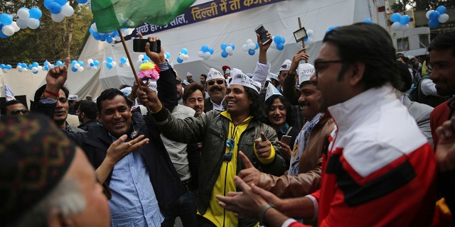 Supporters of the Aam Aadmi Party, or "common man's" party, celebrate as initial results show the party in the lead, at their party office in New Delhi, India, Tuesday, Feb. 11, 2020. The polls put Indian Prime Minister Narendra Modi's Bharatiya Janata Party against the incumbent Aam Aadmi Party, whose pro-poor policies have focused on fixing state-run schools and providing free health care and bus fares for women during the five years in power. (AP Photo/Altaf Qadri)