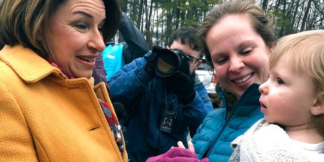 Democratic presidential candidate Sen. Amy Klobuchar, D-Minn., left, greets people outside a New Hampshire primary polling location, Tuesday, Feb. 11, 2020, in Manchester, N.H. (AP Photo/Holly Ramer)