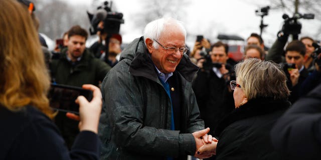 Democratic presidential candidate Sen. Bernie Sanders, I-Vt., meets with people outside a polling place where voters will cast their ballots in a primary election, in Manchester, N.H., Tuesday, Feb. 11, 2020. (AP Photo/Matt Rourke)