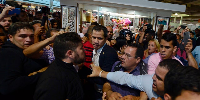 Opposition leader Juan Guaido, center, arrives at the Simon Bolivar International Airport in La Guaira, Venezuela, Tuesday, Feb. 11, 2020. Guaido returned home from a tour of nations that back his effort to oust socialist leader Nicolas Maduro. (AP Photo/Matias Delacroix)
