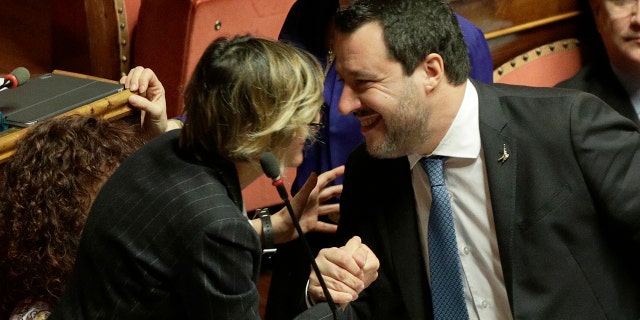 Opposition populist leader Matteo Salvini greets senator Giulia Bongiorno during the debate at the Italian Senate on whether to allow him to be prosecuted – as he demands to be -- for alleging holding migrants hostage for days aboard coast guard ship Gregoretti instead of letting them immediately disembark in Sicily, while he was interior minister. Salvini says being on trial for alleged kidnapping is tantamount to defending his country from illegal migrants he blames for crime and for subtracting jobs from Italians. (AP Photo/Andrew Medichini)