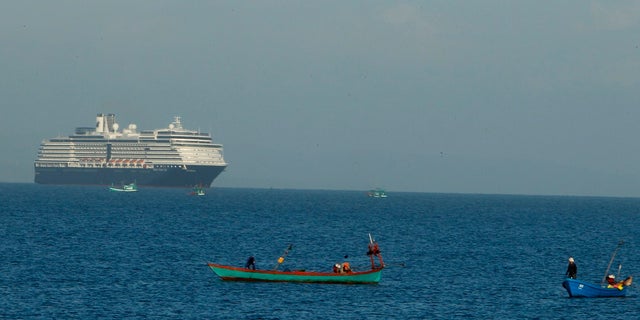 The MS Westerdam sails off Sihanoukville, Cambodia on Thursday. Holland America Line said the ship has been turned away by the Philippines, Taiwan, Japan and Thailand, though its operator said no cases of the disease have been confirmed among the more than 2,200 passengers and crew. (AP Photo/Heng Sinith)