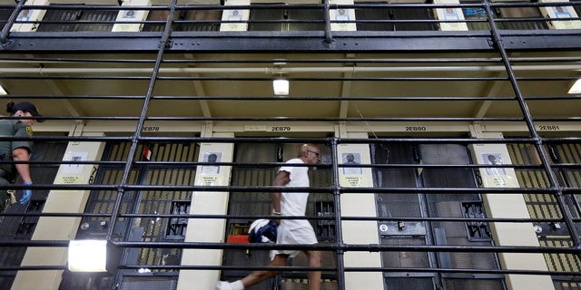 A condemned inmate walks along the east block of death row at San Quentin State Prison in San Quentin, Calif. More than 700 condemned inmates on California's largest-in-the-nation death row will soon have a chance to voluntarily transfer from San Quentin to other high-security prisons under a program required by the passage of a 2016 ballot initiative. (AP Photo/Eric Risberg, File)