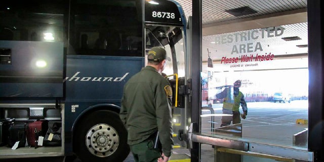 In this Thursday, Feb. 13 photo, agents for Customs and Border Protection board a Greyhound bus headed for Portland, Ore., at the Spokane Intermodal Center, a terminal for buses and Amtrak in Spokane, Wash. (AP Photo/Nicholas K. Geranios)