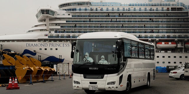 A bus leaves a port where the quarantined Diamond Princess cruise ship is docked Saturday, Feb. 15, 2020, in Yokohama, near Tokyo. A viral outbreak that began in China has infected more than 67,000 people globally. The World Health Organization has named the illness COVID-19, referring to its origin late last year and the coronavirus that causes it. (AP Photo/Jae C. Hong)