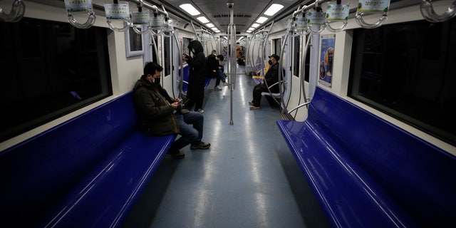 Commuters ride in a quiet subway train during the morning rush hour in Beijing, Monday, Feb. 17, 2020. Chinese authorities on Monday reported a slight upturn in new virus cases and hundred more deaths for a total of thousands since the outbreak began two months ago. (AP Photo/Andy Wong)