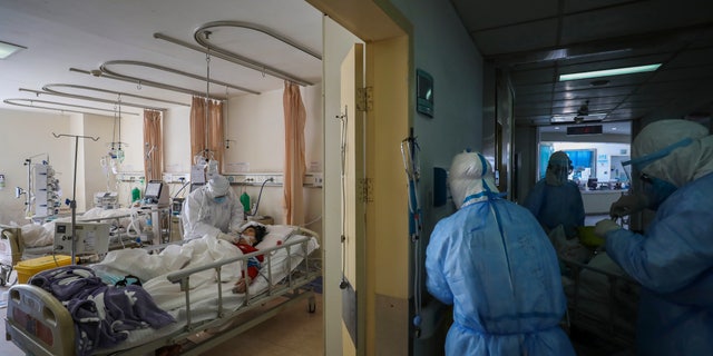 Medical personnel provide treatment to a new coronavirus patient at a hospital in Wuhan in central China's Hubei province. (Chinatopix via AP)