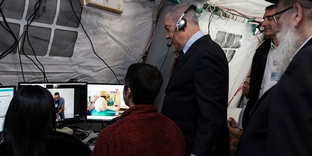 Israeli Prime Minister Benjamin Netanyahu visits an observation tent at the Chaim Sheba Medical Center at Tel Hashomer for discussions about the coronavirus, in Ramat Gan, Israel on Wednesday. Doctors can monitor patients that have been in contact with the virus from the tent. (Heidi Levine/Pool via AP).