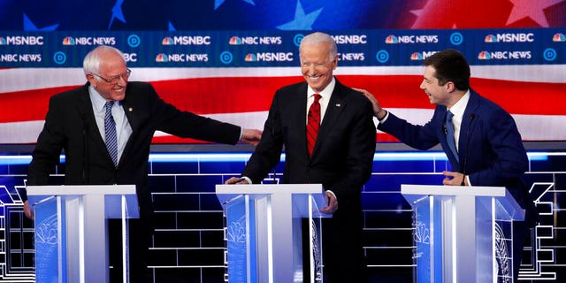Democratic presidential candidates Sen. Bernie Sanders, I-Vt., left, and former South Bend Mayor Pete Buttigieg, right, reach for former Vice President Joe Biden during a Democratic presidential primary debate Wednesday, Feb. 19, 2020, in Las Vegas, hosted by NBC News and MSNBC. (AP Photo/John Locher)