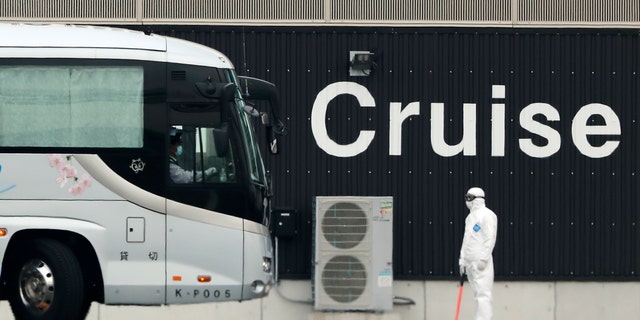 A bus carrying passengers from the quarantined Diamond Princess cruise ship prepares to leave a port in Yokohama, near Tokyo, Thursday, Feb. 20, 2020. (Associated Press)