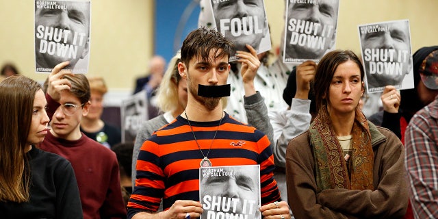 Jan. 8, 2019: Protesters hold signs as they turn their backs on a meeting of the Virginia State Air Quality Control Board in Richmond, Va. The U.S. Supreme Court is set to wade into a long-running battle between developers of a 605-mile natural gas pipeline and environmental groups who oppose the pipeline crossing the storied Appalachian Trail. On Monday, Feb. 24, 2020, the high court will hear arguments on a critical permit needed by developers of the Atlantic Coast Pipeline. (AP Photo/Steve Helber, File)