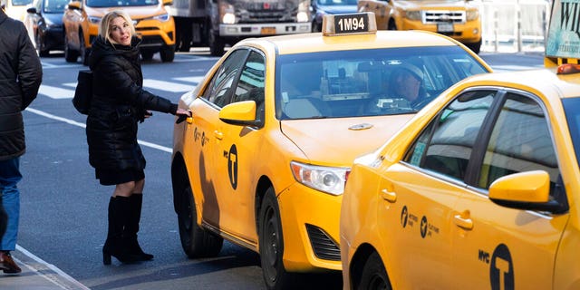 A passenger gets into a taxi in New York. Drivers entering the heart of New York City potentially will have to pay an extra $9 to $23 as soon as the end of next year.