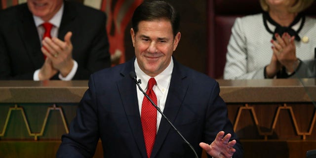 FILE - In this Jan. 13, 2020 file photo Arizona Republican Gov. Doug Ducey, foreground, gestures during his State of the State address as Senate president Karen Fann, R-Prescott, right, and House Speaker Rusty Bowers, R-Mesa, left, listen in on the opening day of the legislative session at the Capitol in Phoenix. (AP Photo/Ross D. Franklin,File)
