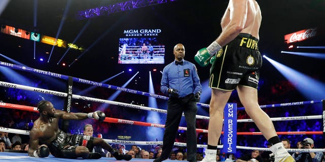 Tyson Fury, of England, knocks down Deontay Wilder during a WBC heavyweight championship boxing match Saturday, Feb. 22, 2020, in Las Vegas. (AP Photo/Isaac Brekken)
