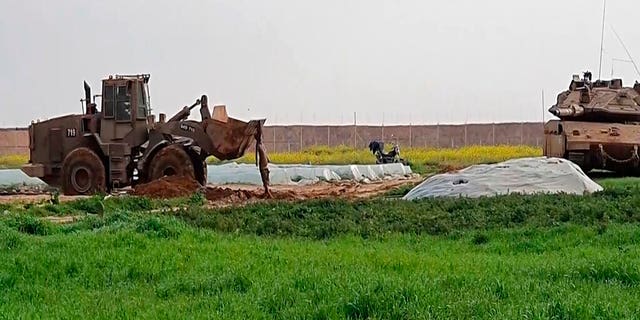 In this frame grab from video, an Israeli military vehicle removed the body of a Palestinian militant along the Gaza-Israel border on Sunday. (AP Photo)