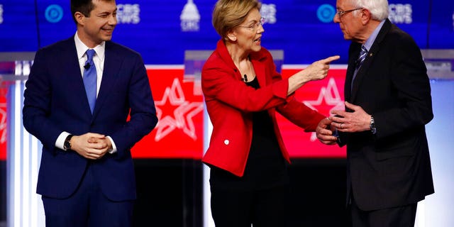 From left, Democratic presidential candidates former South Bend Mayor Pete Buttigieg, watches as Sen. Elizabeth Warren, D-Mass., and Sen. Bernie Sanders, I-Vt., talk before a Democratic presidential primary debate at the Gaillard Center, Tuesday, Feb. 25, 2020, in Charleston, S.C., co-hosted by CBS News and the Congressional Black Caucus Institute. (AP Photo/Patrick Semansky)