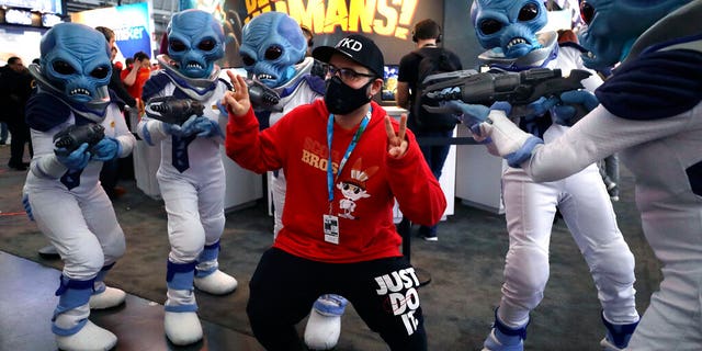 Whistleblower says HHS sent workers to handle possible coronavirus patients without gear, training 2 Eric Vita, of Morris Plains, N.J., center, wears a protective mask while posing for a photograph with people dressed as "Crypto," the main character in the video game "Destroy All Humans!," Thursday, Feb. 27, 2020, at the Pax East conference, in Boston. Vita said concerns about the coronavirus played a role in his decision to wear a mask to the conference. (AP Photo/Steven Senne)