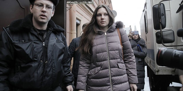 Alla Ilyina, who broke out of the hospital on Feb. 7 after learning that she would have to spend 14 days in isolation instead of the 24 hours doctors promised her, is escorted by a bailiff from a court after a session in St. Petersburg, Russia, on Monday. (AP)