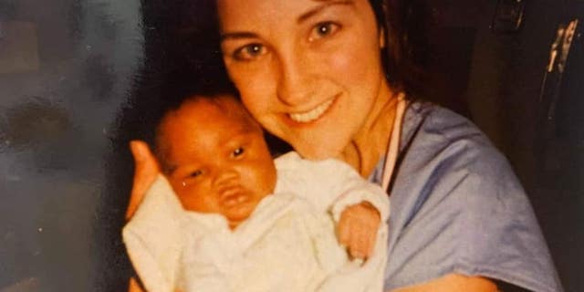 Lissa McGowan, a nurse at Saint Peter's University Hospital in New Brunswick, N.J., holding then-newborn David Caldwell decades ago.