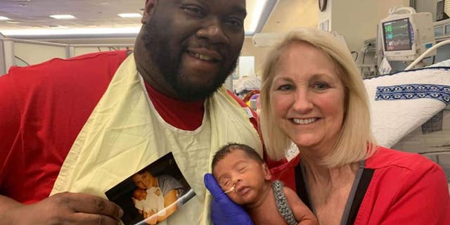 David Caldwell posing for a photo with NICU nurse Lissa McGowan, who took care of him as a newborn in the same hospital where she looked after his newborn son.