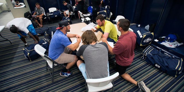 FILE - In this April 8, 2015, file photo, members of the Biloxi Shuckers minor league baseball team eat lunch before practice. (AP Photo/Michael Spooneybarger, File)