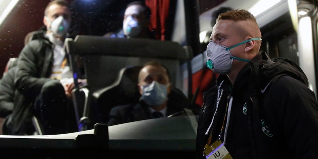 Bulgarian soccer team Ludogorets players, wearing protective face masks, get on a coach bus heading to the San Siro Stadium in Milan, Italy, Thursday, Feb. 27, 2020. (AP Photo/Luca Bruno)