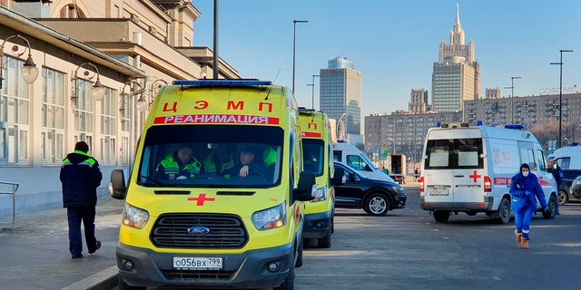 In this file photo taken on Friday, Feb. 21, 2020, Ambulance cars are parked while medics check passengers where a passenger was identified with suspected coronavirus after arriving from Kyiv at Kievsky rail station in Moscow, Russia.