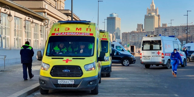 In this file photo taken on Friday, Feb. 21, 2020, Ambulance cars are parked while medics check passengers where a passenger was identified with suspected coronavirus after arriving from Kyiv at Kievsky rail station in Moscow, Russia.