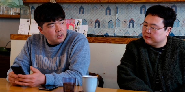 In this Wednesday, Feb. 19, 2020, photo, props manager Joo Dong-man, left, speaks as costume manager Yang Hee-hwa listens during an interview at a cafe in Ilsan, South Korea. (AP Photo/Juwon Park)