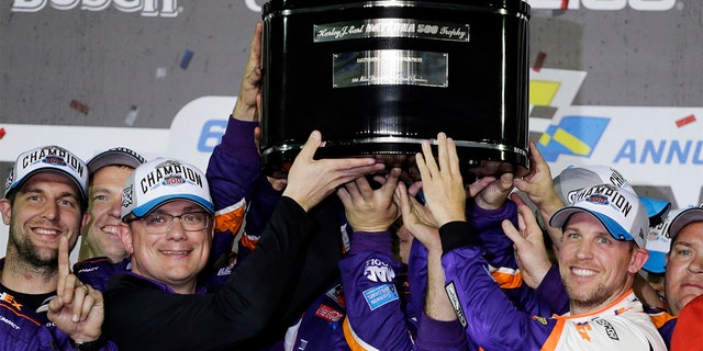 Denny Hamlin, right, celebrating as he and crew members hoisted the championship trophy after winning the Daytona 500. (AP Photo/Terry Renna)