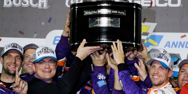 Denny Hamlin, right, celebrating as he and crew members hoisted the championship trophy after winning the Daytona 500. (AP Photo/Terry Renna)