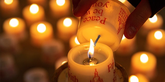 A child lights a candle in the Frauenkirche cathedral (Church of Our Lady) in Dresden, Germany. (AP Photo/Jens Meyer)