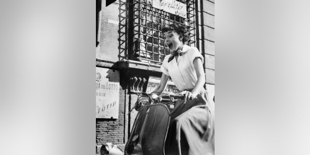 Audrey Hepburn gleefully drives a motorscooter on the set of 'Roman Holiday.'