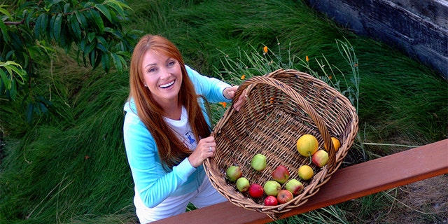 Actress and artist Jane Seymour stands on the deck of her home overlooking the Pacific Ocean with items picked from her garden in Malibu, California.